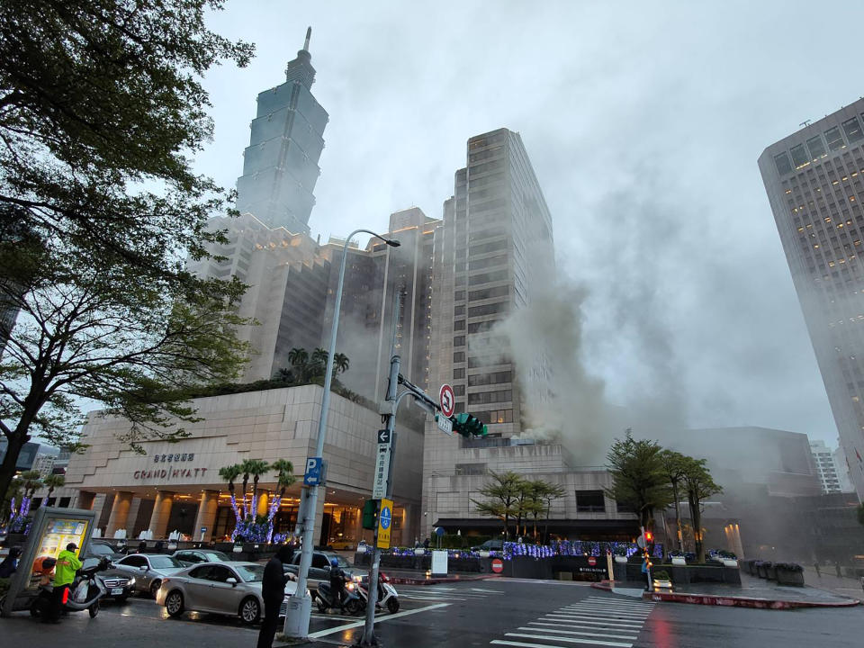 台北市信義區君悅酒店17日下午驚傳火警，大樓濃煙密佈。台北市消防局獲報後，立即出動各式車輛34輛、97人馳援。（翻攝照片）