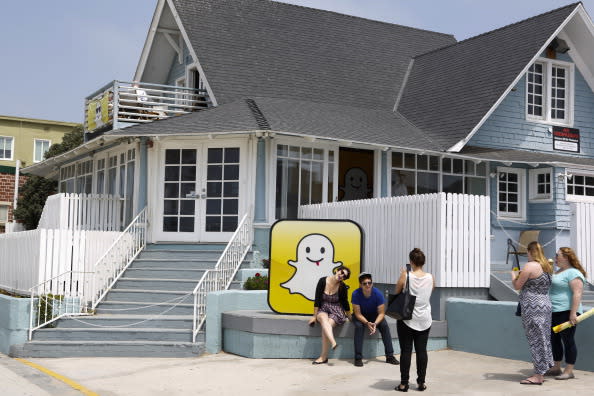 People take pictures in front of the Snapchat Inc. headquarters on the strand at Venice Beach in Los Angeles, California, U.S., on Wednesday, Aug. 14, 2013. (Source: Bloomberg)