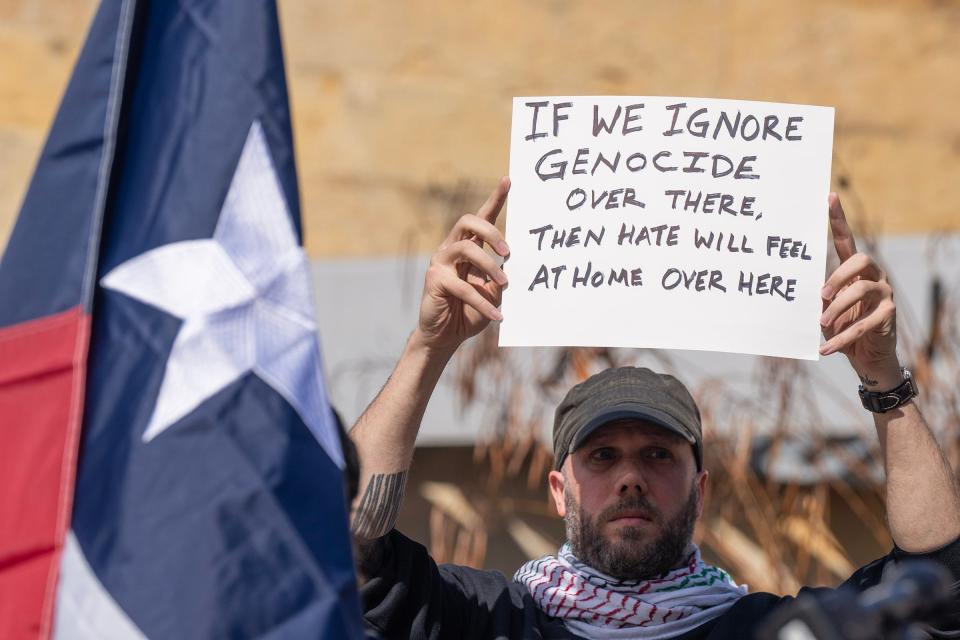 Cliff Clive holds up a pro-Palestinian sign during Tuesday's news conference at Austin City Hall held after the weekend stabbing of Zacharia Doar.