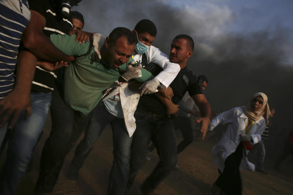 Medics and protesters evacuate a serious wounded youth who was shot at his back, from near the fence of the Gaza Strip border with Israel east of Khan Younis, southern Gaza Strip, Friday, Oct. 19, 2018. (AP Photo/Adel Hana)
