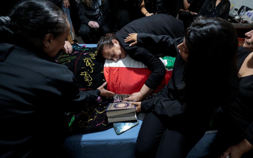 Fatma Kanso, mother of Issam Abdullah, a Lebanese national and Reuters videojournalist who was killed in southern Lebanon by shelling from the direction of Israel, mourns over her son's body during his funeral in his home town of Al Khiyam, Lebanon October 14, 2023.