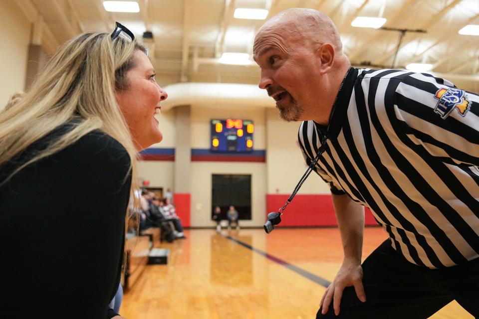 Scott Smith sprints over to his wife Michelle before the start of a girls basketball game to say, "Be good," while he referees the game on Wednesday, Feb. 8, 2023 at Western Boone Junior High School in Thorntown.