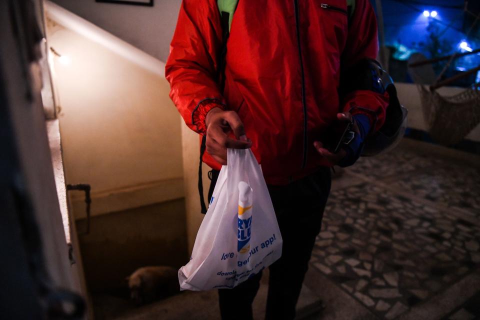 In this photograph taken on February 6, 2019, Indian delivery man Ujjwal Singhal working with the food delivery app Swiggy carries an order to a customer in New Delhi. - A surge in the popularity of food-ordering apps like Uber Eats, Swiggy and Zomato provides a welcome source of income for many as India's unemployment rate sits reportedly at a staggering 45-year high. (Photo by CHANDAN KHANNA / AFP) / To go with 'INDIA-ECONOMY-FOOD-TECHNOLOGY,FOCUS' by Vishal MANVE        (Photo credit should read CHANDAN KHANNA/AFP via Getty Images)