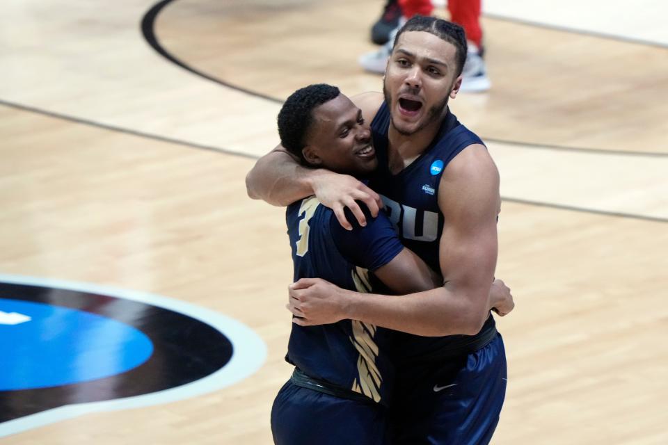 Oral Roberts guard Max Abmas (3) and forward Kevin Obanor (0) celebrate after the Golden Eagles' overtime victory over Ohio State in the first round.