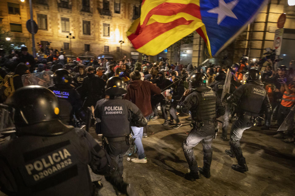 Catalan police officers clash with Catalan pro-independence protesters during a demonstration in Barcelona, Spain, Saturday, Oct. 26, 2019. Protests turned violent last week after Spain's Supreme Court convicted 12 separatist leaders of illegally promoting the wealthy Catalonia region's independence and sentenced nine of them to prison. (AP Photo/Emilio Morenatti)