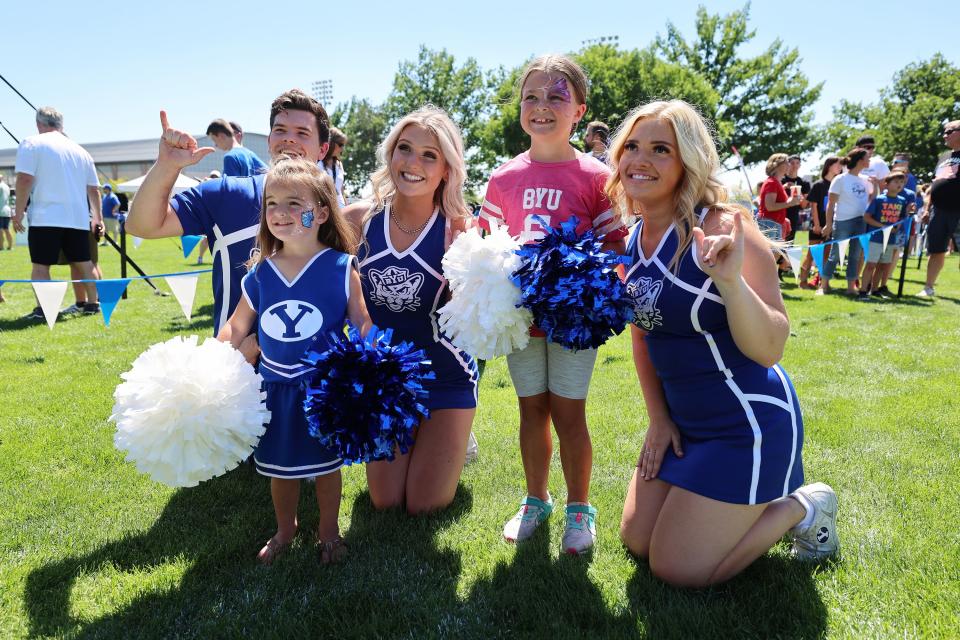 BYU cheerleaders Kaden Watt, Vivian Andrus and Kylie Wood pose for photos with young fans Navy Milne and Lexie Milne as BYU holds a party to celebrate their move into the Big 12 Conference with music, games and sports exhibits in Provo on Saturday, July 1, 2023. | Scott G Winterton, Deseret News