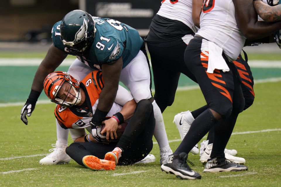 Cincinnati Bengals' Joe Burrow (9) is tackled by Philadelphia Eagles' Fletcher Cox (91) during overtime of an NFL football game, Sunday, Sept. 27, 2020, in Philadelphia. (AP Photo/Chris Szagola)