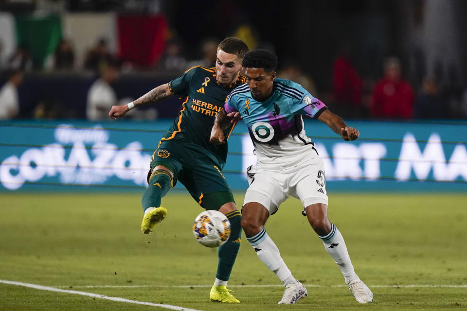 LA Galaxy midfielder Tyler Boyd, left, clears the ball past Minnesota United defender Ethan Bristow during the first half of an MLS soccer match Wednesday, Sept. 20, 2023, in Carson, Calif. (AP Photo/Ryan Sun)