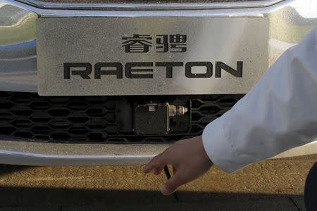 An engineer points at a radar sensor on a Changan Automobile self-driving car after the car completed a test drive from Chongqing to Beijing, China, April 16, 2016. REUTERS/Kim Kyung-Hoon