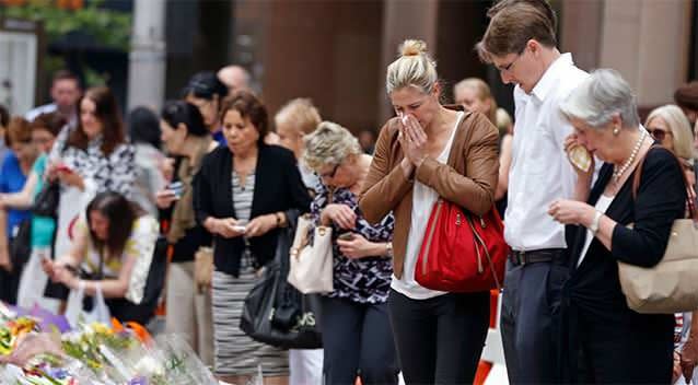 Unidentified relatives of Katrina Dawson (R) take a moment after laying a floral tribute in Martin Place. Photo: Reuters.