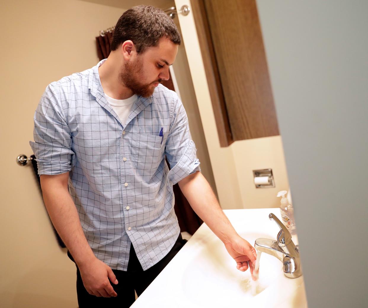 Austin Carter, Brown County public health sanitarian, checks for hot water during a routine inspection of a short-term rental property on Aug. 7, 2019, in Ashwaubenon.