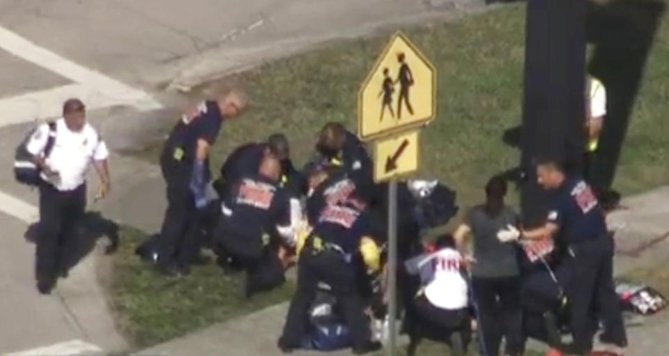 <p>Rescue workers deal with a victim near Marjory Stoneman Douglas High School during a shooting incident in Parkland, Florida, U.S. February 14, 2018 in a still image from video. (Photo: WSVN.com via Reuters) </p>