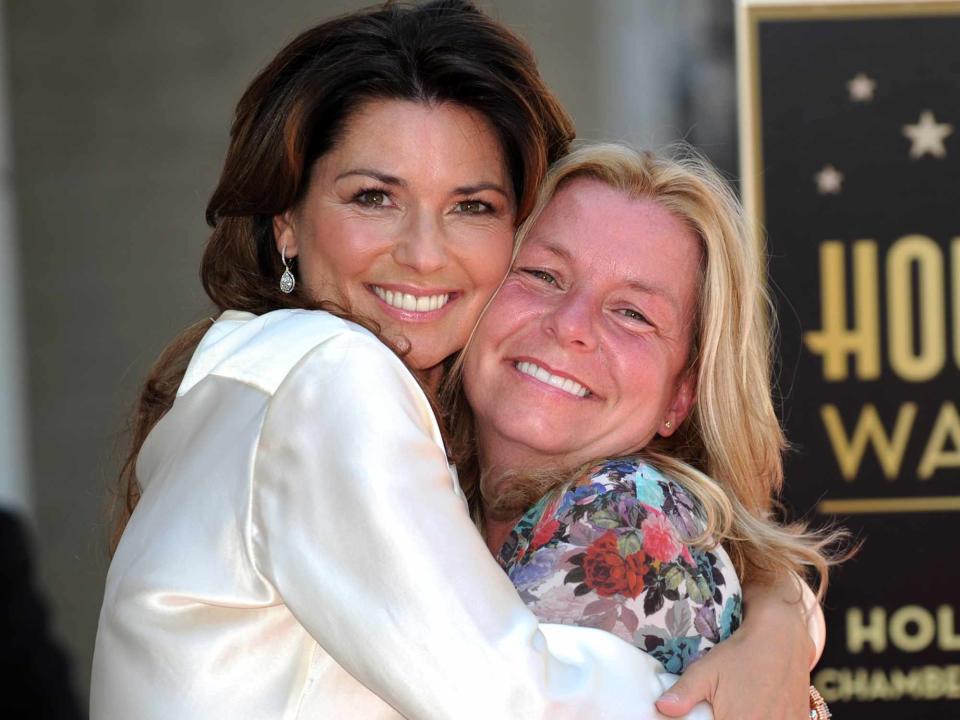 <p>GABRIEL BOUYS/AFP/Getty</p> Shania Twain and her sister Carrie-Ann Edwards in 2011