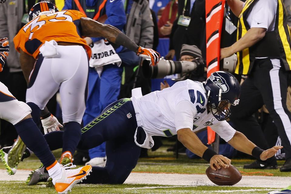 Seattle Seahawks' Russell Wilson is stopped short of a first down during the first half of the NFL Super Bowl XLVIII football game against the Denver Broncos Sunday, Feb. 2, 2014, in East Rutherford, N.J. Broncos' Duke Ihenacho is at left. (AP Photo/Paul Sancya)