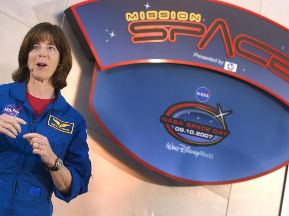 A woman stands in front of a mission space sign