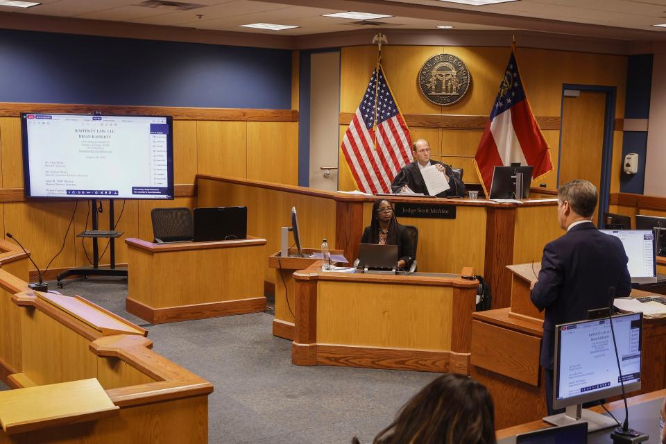 Brian Rafferty, right, attorney for Sidney Powell, addresses the court during a motions hearing in front of Fulton County Superior Court Judge Scott McAfee, back, in Atlanta, Thursday, Oct. 5, 2023. Nineteen people, including former President Donald Trump, were indicted in August and accused of participating in a wide-ranging illegal scheme to overturn the results of the 2020 presidential election. (Erik S. Lesser/Pool Photo, via AP)