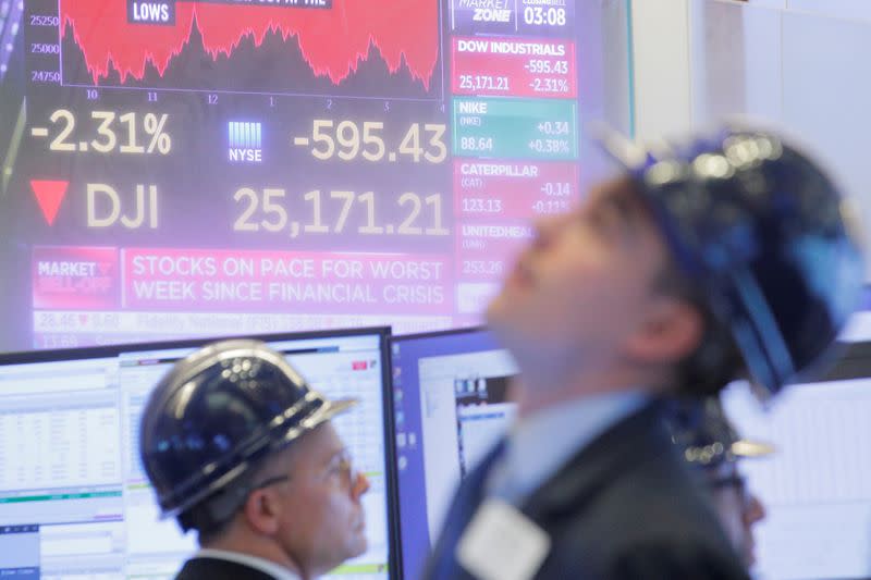 FILE PHOTO: Traders work on the floor at the NYSE in New York