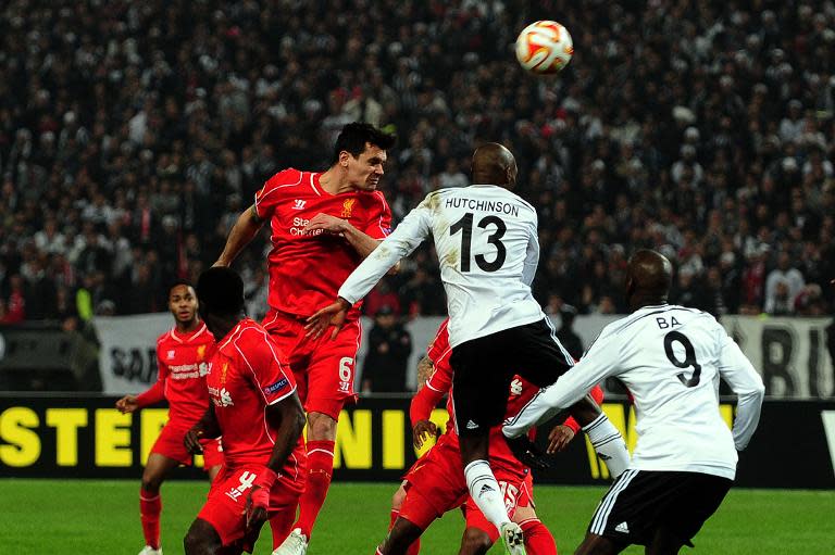 Liverpool's Dejan Lovren (up L) heads the ball next to Besiktas' Atiba Hutchinson (up R) during their second-leg round of 32 UEFA Europa League match in Istanbul on February 26, 2015