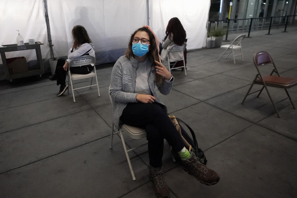 Angela Margos, a tourist on her way to visit Maui, sits in a waiting area for test results at the SFO COVID-19 rapid testing site before a United Airlines flight to Hawaii at San Francisco International Airport in San Francisco, Thursday, Oct. 15, 2020. Coronavirus weary residents and struggling business owners in Hawaii will be watching closely as tourists begin to return to the islands on Thursday without having to self-quarantine upon arrival. (AP Photo/Jeff Chiu)