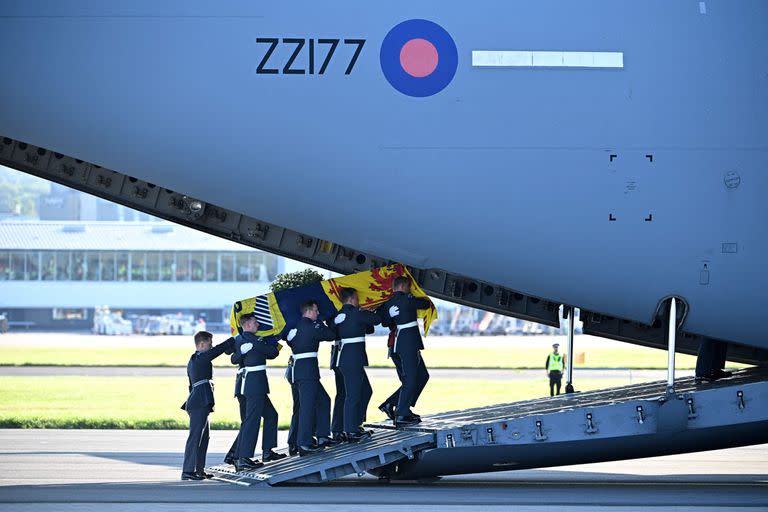 Los portadores del féretro del Queen's Color Squadron de la Royal Air Force (RAF) llevan el ataúd de la reina Isabel II, envuelto en el estandarte real de Escocia, en un avión C17 de la RAF en el aeropuerto de Edimburgo