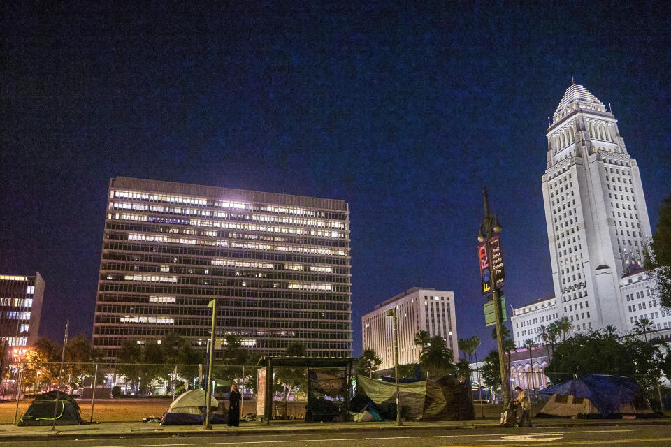 Tents regularly pop up on the pavement and parks outside Los Angeles City Hall, seen right, downtown Los Angeles early morning Wednesday, June 26, 2024. The number of homeless residents counted in Los Angeles County has dipped slightly, decreasing by about 0.3% since last year as California continues to struggle with the long-running crisis of tens of thousands of people sleeping in cars and encampments. (AP Photo/Damian Dovarganes)