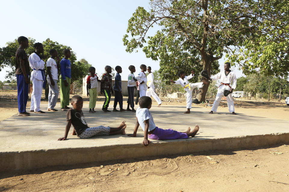 Young boys and girls go through taekwondo kicking drills during a practice session with Natsiraishe Maritsa in the Epworth settlement about 15 km southeast of the capital Harare, Saturday Nov. 7, 2020. In Zimbabwe, where girls as young as 10 are forced to marry due to poverty or traditional and religious practices, a teenage martial arts fan 17-year old Natsiraishe Maritsa is using the sport to give girls in an impoverished community a fighting chance at life. (AP Photo/Tsvangirayi Mukwazhi)