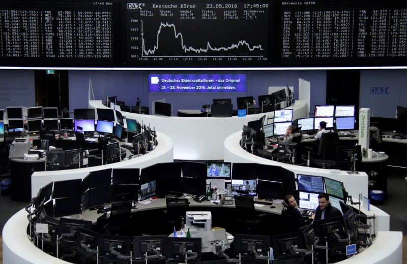 Traders work at their screens in front of the German share price index DAX board at the stock exchange in Frankfurt, Germany May 23, 2016. REUTERS/Remote/Staff