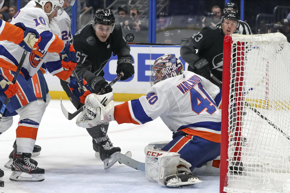 New York Islanders goaltender Semyon Varlamov, of Russia, and Tampa Bay Lightning's Mitchell Stephens (67) look for a loose rebound during the second period of an NHL hockey game Saturday, Feb. 8, 2020, in Tampa, Fla. (AP Photo/Mike Carlson)
