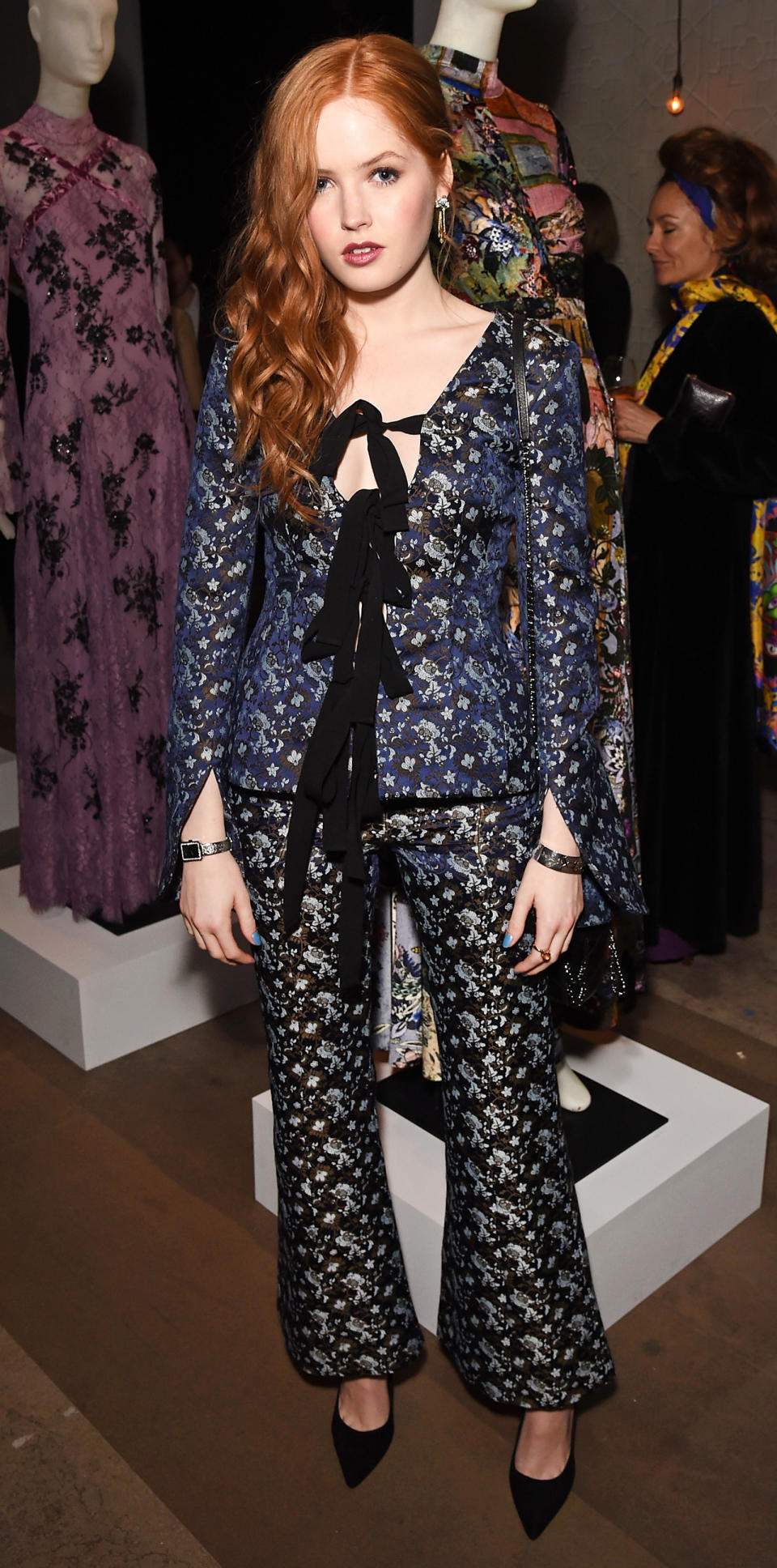 <p>Ellie Bamber made spring florals actually groundbreaking in this matching brocade set with ornate ribbon detailing, slit sleeves, and a crop flare fit. She kept the look elegant but modern with pointed-toe Kurt Geiger pumps and hard metal jewelry.</p>