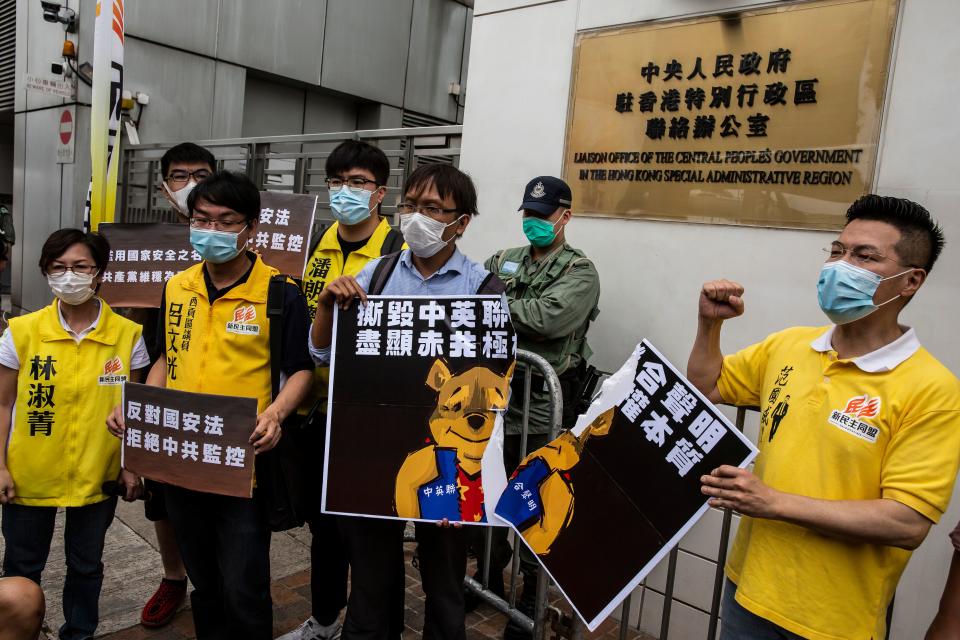 Pro-democracy activists tear a placard of Winnie-the-pooh that represents Chinese President Xi Jinping during a protest against a proposed new security law outside the Chinese Liaison Office in Hong Kong on May 24, 2020. - The proposed legislation is expected to ban treason, subversion and sedition, and follows repeated warnings from Beijing that it will no longer tolerate dissent in Hong Kong, which was shaken by months of massive, sometimes violent anti-government protests last year. (Photo by ISAAC LAWRENCE / AFP) (Photo by ISAAC LAWRENCE/AFP via Getty Images)