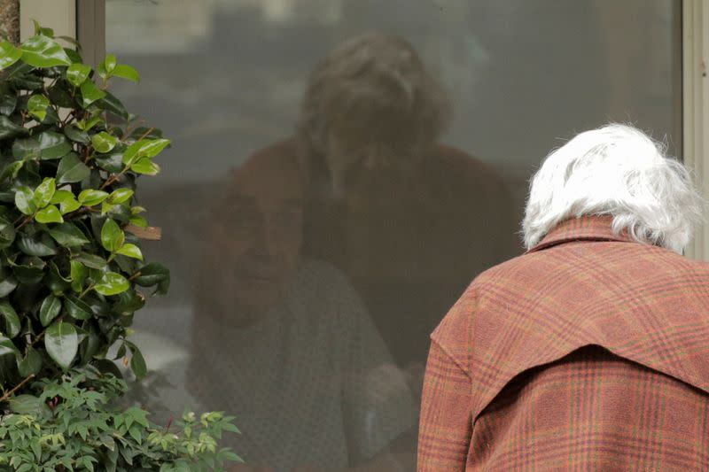 Gene Campbell talks through a window with his wife of more than 60 years, Dorothy Campbell, at the Life Care Center of Kirkland, the long-term care facility linked to several confirmed coronavirus cases in the state, in Kirkland