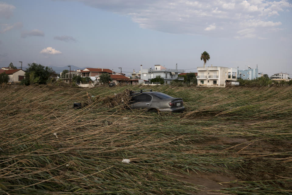 A sunken car near the seashore following a storm at the village of Bourtzi, on Evia island, northeast of Athens, on Sunday, Aug. 9, 2020. Five people, including en elderly couple and an 8-month-old baby have been found dead, two more are missing and dozens have been trapped in their homes and cars as a storm hits the island of Evia in central Greece, authorities said Sunday. (AP Photo/Yorgos Karahalis)