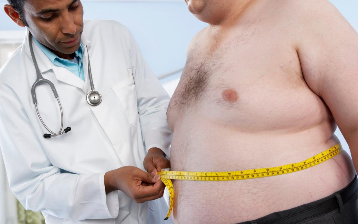 A GP measures the waist of an obese patient - ADAM GAULT/SPL/Science Photo Library RF