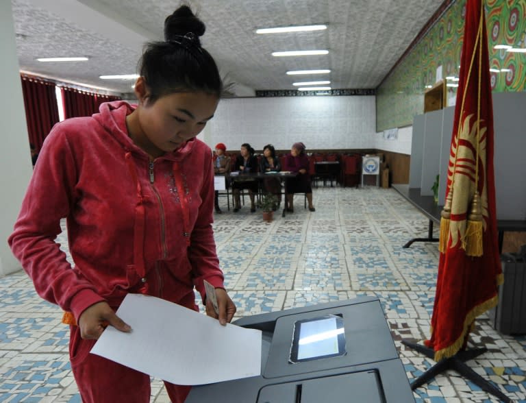 A woman votes at a polling station during Kyrgyz parliamentary elections in the village of Kara-Zhigach, outside Bishkek, on October 4, 2015