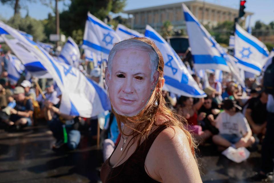 A demonstrator wears a mask depicting Israeli Prime Minister Benjamin Netanyahu during a sit-in to block the entrance of the Knesset, Israel's parliament, on Monday in Jerusalem.