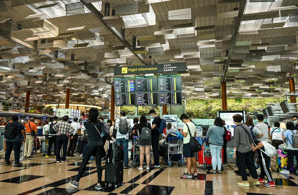 Travellers queue to check-in for their flight departure at Singapore Changi airport on December 7, 2022. (Photo by Roslan RAHMAN / AFP) (Photo by ROSLAN RAHMAN/AFP via Getty Images)