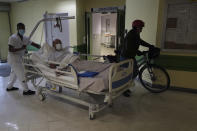 A patient is carried in a bed at the Hospital of Argenteuil, north of Paris, Friday Sept. 25, 2020. France's health agency announced Thursday evening that the country has had 52 new deaths and has detected over 16,000 new cases of coronavirus in 24 hours. (AP Photo/Francois Mori)