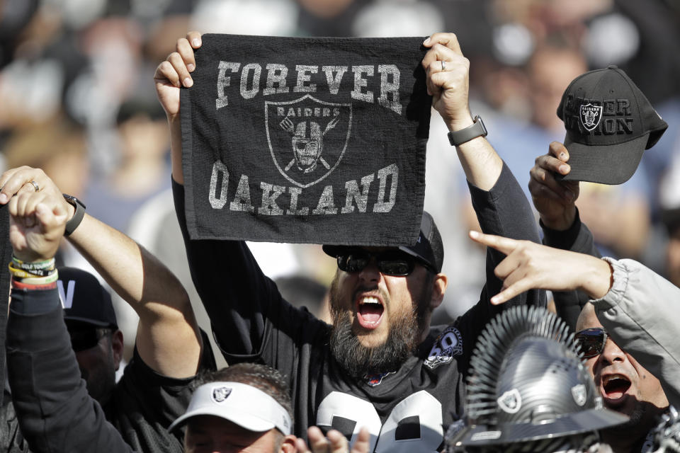 An Oakland Raiders fans holds up a towel and cheers during the first half of an NFL football game against the Jacksonville Jaguars in Oakland, Calif., Sunday, Dec. 15, 2019. (AP Photo/Ben Margot)