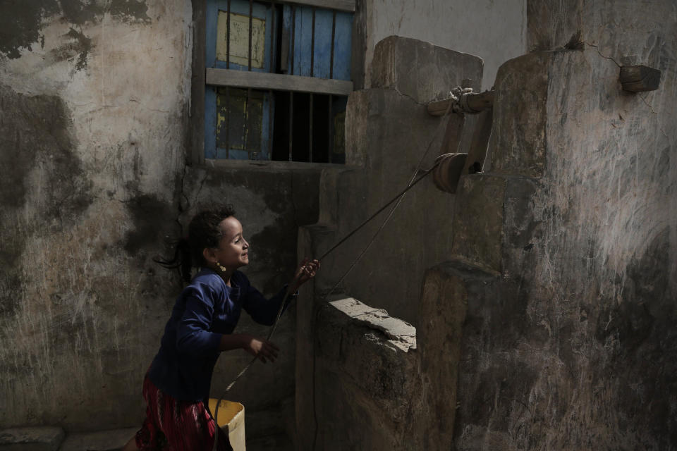 A girl pulls water from a well in the home of Ahmed al-Kawkabani, leader of the southern resistance unit in Hodeida, in al-Khoukha, Yemen Feb. 12, 2018. (AP Photo/Nariman El-Mofty)