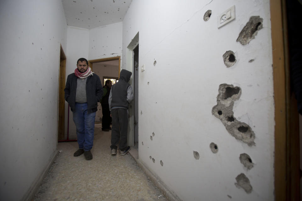 Palestinians look at a damage after an Israeli raid killed Ashraf Naalweh during an arrest raid in the Asker refugee camp near the West Bank city of Nablus, Thursday, Dec. 13, 2018. Israel accuses Naalweh of shooting to death two Israelis and wounding another at an attack on a West Bank industrial zone in October. He fled the scene and Israeli forces have been searching for him since. (AP Photo/Majdi Mohammed)