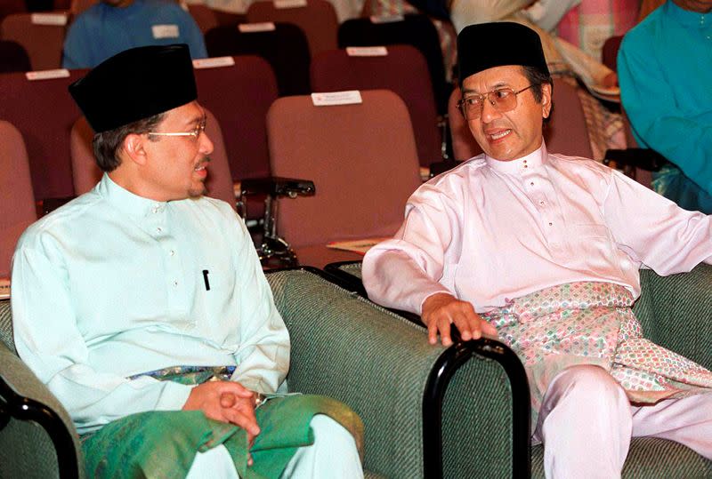 FILE PHOTO: Malaysia's Prime Minister Mahathir Mohamad chats with deputy premier Anwar Ibrahim, who is also the finance minister, in Kuala Lumpur