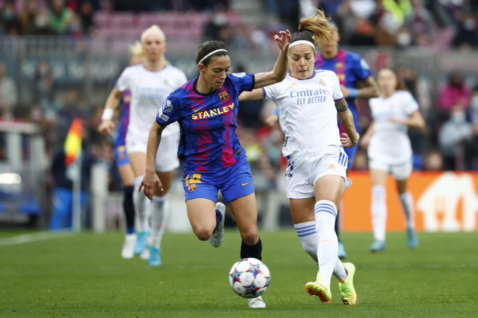 ARCHIVO - Foto del 30 de marzo del 2022, Aitana Bonmatí del Barcelona pelea por el balón con Athenea del Castillo del Real Madrid en los cuartos de final de la Liga de Campeones femenina en el Camp Nou. El viernes 2 de junio del 2023, el Barcelona se prepara para disputar su cuarta final de Liga de Campeones en cinco años ante el Wolfsburg el sábado en el estadio del PSV. (AP Foto/Joan Monfort, Archivo)