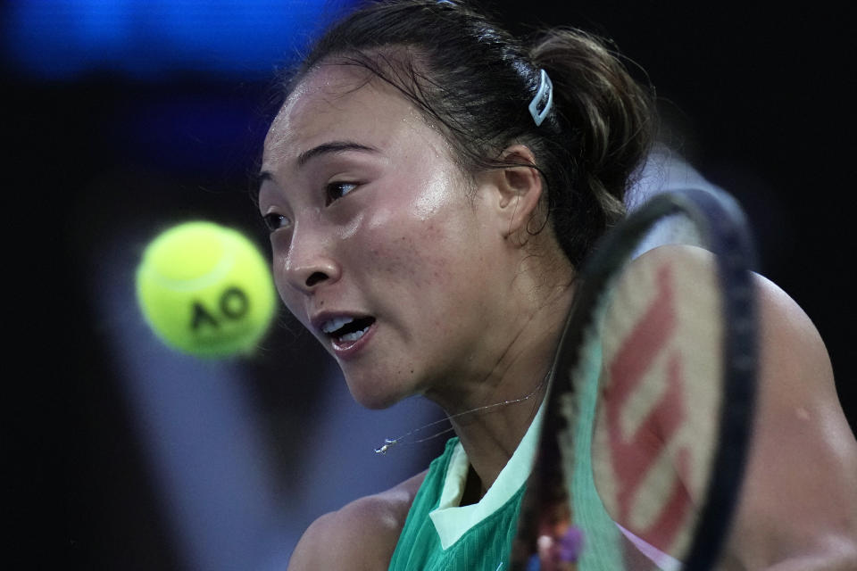 Zheng Qinwen of China plays a backhand return to Aryna Sabalenka of Belarus during the women's singles final at the Australian Open tennis championships at Melbourne Park, Melbourne, Australia, Saturday, Jan. 27, 2024. (AP Photo/Andy Wong)