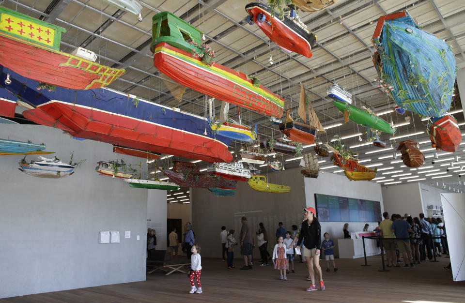 In this Saturday, Dec. 7, 2013 photo, a piece titled "For Those In Peril on the Sea" by the Guyana-raised artist Hew Locke, appears on display at the Perez Art Museum Miami, in Miami. The colorful display is both a playful nod to South Florida's maritime culture and a somber reference to those perilous journeys so many make to get here. (AP Photo/Lynne Sladky)