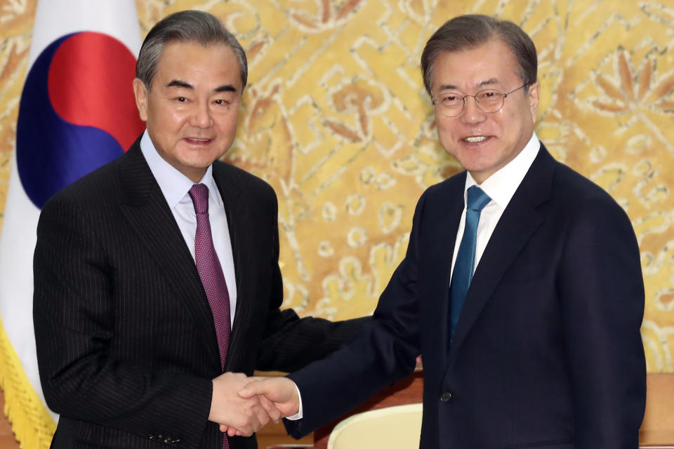 South Korean President Moon Jae-in, right, shakes hands with Chinese Foreign Minister Wang Yi during a meeting at the presidential Blue House in Seoul, South Korea, Thursday, Dec. 5, 2019. Wang arrived in South Korea on Wednesday for his first visit in four years amid efforts to patch up relations damaged by Seoul's decision to host a U.S. anti-missile system that Beijing perceives as a security threat. (Lee Jin-wook/Yonhap via AP)