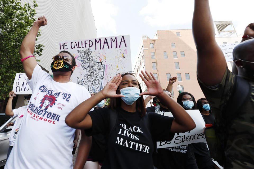 In this June 6, 2020, photo, Maisie Brown, 18, second from left, a member of the Mississippi branch of Black Lives Matter, leads a protest march with others during a rally in Jackson, Miss., over police brutality. Young activists like Brown are energizing the debate about removing the Confederate battle emblem from the Mississippi state flag. Brown says elected officials must step up and change the flag. (AP Photo/Rogelio V. Solis)