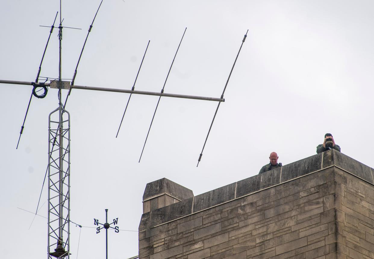 Law enforcement officers on top of the Indiana Memorial Memorial Union watch the pro-Palestine demonstrators at Indiana University's Dunn Meadow on Friday, April 26, 2024. Indiana State Police Superintendent Doug Carter confirmed the officers had "sniper capabilities." He added: "The analogy that we're going to create another Kent State was completely disingenuous and not truthful."