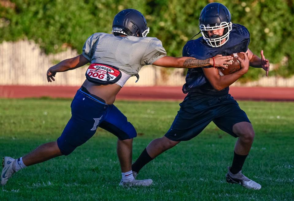 Judah Andrade, left, pursues Josh Corvera during Farmersville football practice Friday, July 28, 2023.