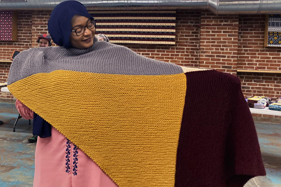 Aisha Bitini holds a handmade blanket she selected at a Welcome Blanket giveaway at the Association of Africans Living in Vermont, Tuesday, March 21, 2023, in Burlington, Vt. The blankets were made by Vermont and out-of-state crafters to welcome refugees to the community as part of the national Welcome Blanket project. (AP Photo/Lisa Rathke)