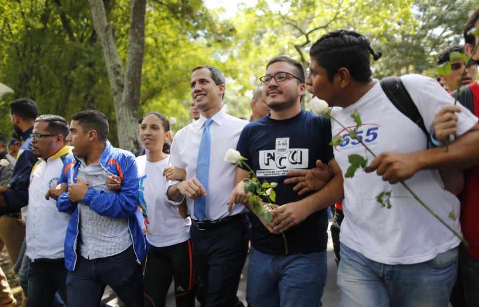 Venezuelan opposition leader, and self-proclaimed interim president of Venezuela, Juan Guaido, center, walks with students at the Central University of Venezuela after a meeting with them in Caracas, Venezuela, Thursday, Nov. 14, 2019. Guaido is calling people across the crisis-torn nation to flood the streets for protests nearly a year since launching an urgent campaign to push President Nicolás Maduro from power. (AP Photo/Ariana Cubillos)